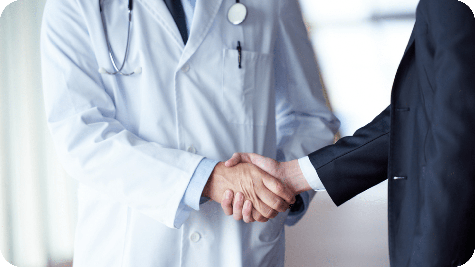 Doctor in a white coat shaking hands with a colleague